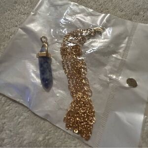 Purple crystal pendant with gold chain. Package never opened.